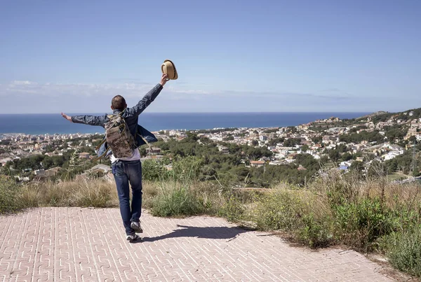 Happy male tourist dancing sur la montagne près de la ville, copier l'espace — Photo