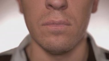 Genç bir adam su ve hafif bir arkaplan ile tablet yiyor.