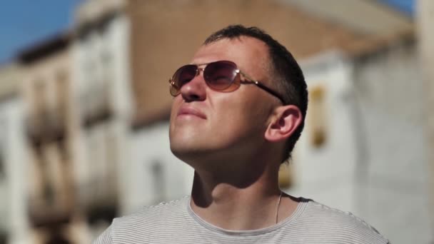 Привлекательный Молодой Человек Очках Смотрит Вверх Стоя Улице Солнечный День — стоковое видео