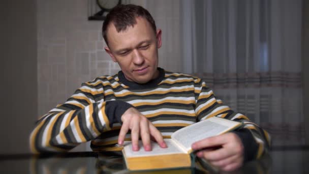Unavený Mladý Muž Studuje Text Zelené Knize Zatímco Sedí Stolu — Stock video