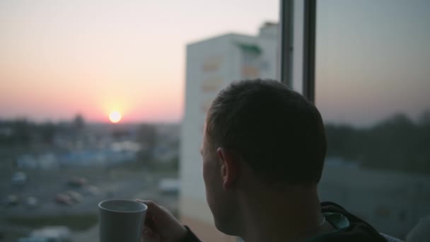 Kille Med Mugg Står Balkongen Solnedgången — Stockvideo