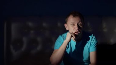 Adam gece geç saatte televizyonda şok edici bir program izliyor..