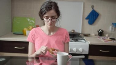 Çekici esmer kız yemek için bir kek açıyor.