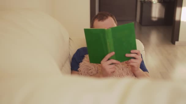 Muž Leží Pohovce Schovaný Přikrývce Čte Starou Zelenou Knihu — Stock video