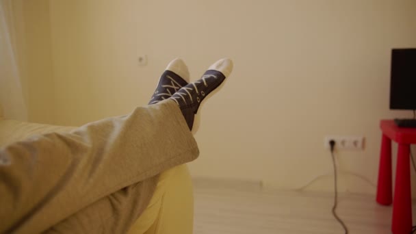 Άντρας Στο Σπίτι Έβαλε Πόδια Του Στον Καναπέ Και Είδε — Αρχείο Βίντεο