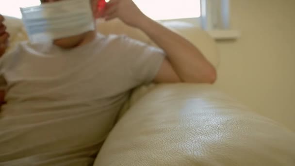 고립적 남자가 소파에 앉아서 의료용 마스크를 — 비디오