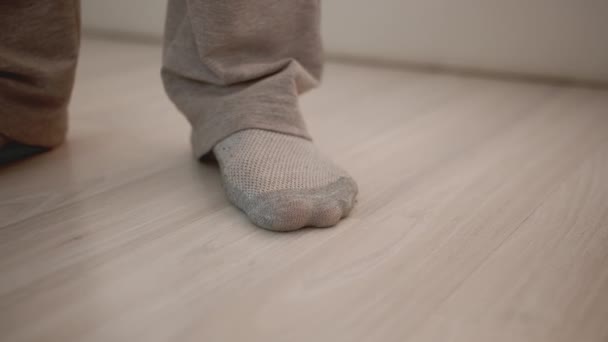在家里穿着袜子的男人的腿在轻薄的板层上 — 图库视频影像
