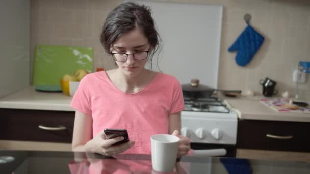 Ragazza Mattino Davanti Una Tazza Guarda Attraverso Messaggi Telefono Cellulare — Video Stock