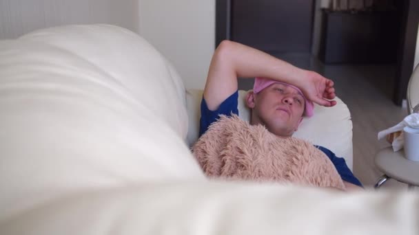 Jovem Deita Sofá Com Uma Forte Dor Cabeça — Vídeo de Stock