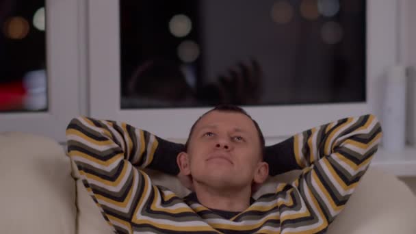 Man Evening Sits Sofa Dreams Background Window — Stock Video