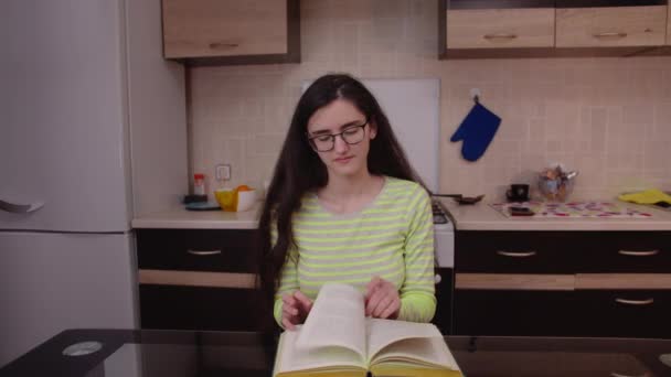 Csinos Barna Olvas Egy Könyvet Egy Asztalnál Konyha Hátterében — Stock videók