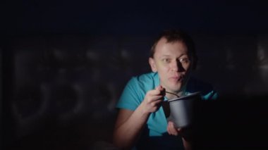 Akşamları televizyon seyredip dondurma yiyen çekici bir adam.