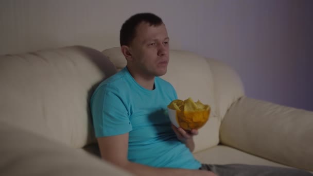 Homem Atraente Sentado Sofá Pela Comendo Batatas Fritas — Vídeo de Stock