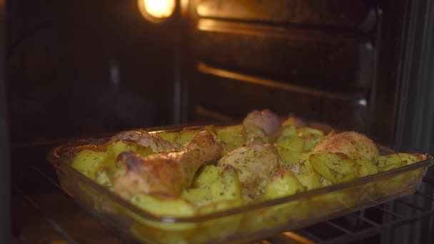 Поднос для выпечки с аппетитной едой, стоящий в духовке с открытой дверью, праздничная еда — стоковое видео