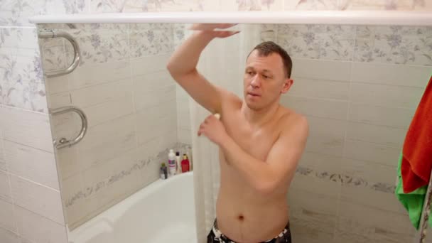 Junger Mann benutzt morgens Deo im Badezimmer — Stockvideo