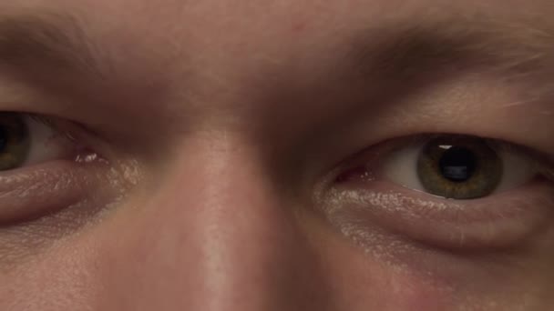 Gray-green eyes of a young man, close-up, camera movement — Stock Video