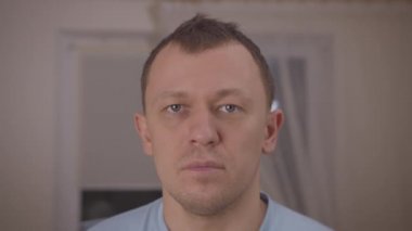 Yorgun bir adamın portresi pencerenin önünde duruyor.