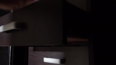 Bir adam raflarda giysili bir şeyler arıyor.