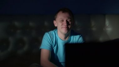 Genç bir adam geceyi TV 'de oturup komik bir program izleyerek geçiriyor.