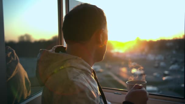 Ein Mann Steht Bei Sonnenuntergang Vor Einem Offenen Fenster Mit — Stockvideo