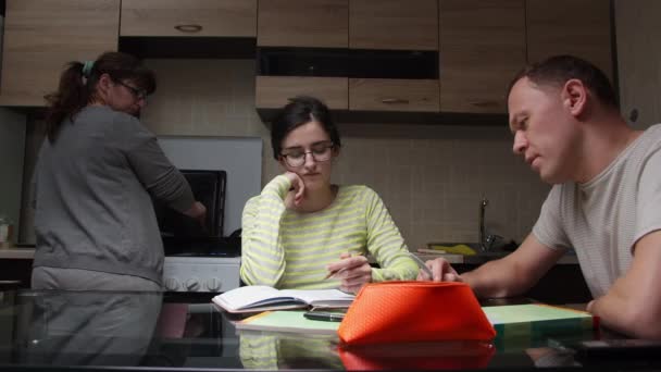 Семья Вместе Кухне Отец Помогает Своей Дочери Выполнять Уроки Мама — стоковое видео