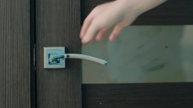 Mavi erkek gömleği kapıyı açar ve odaya girer, yakın plan.