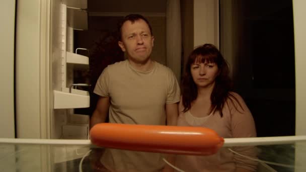 Пара Открывает Холодильник Видят Колбасу Борются Мужчина Берет Себе — стоковое видео
