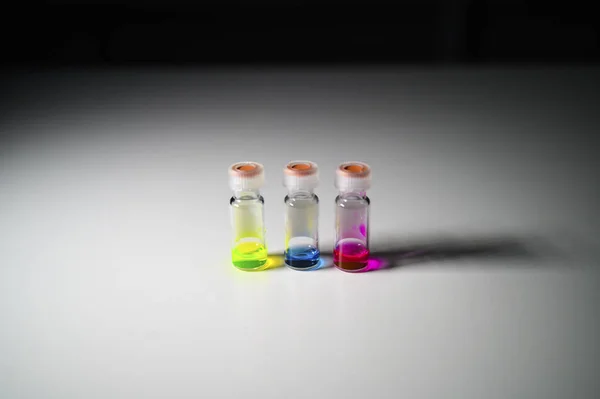 Tres solución colorida en un vial de vidrio LCMS diferente sobre un vial blanco — Foto de Stock