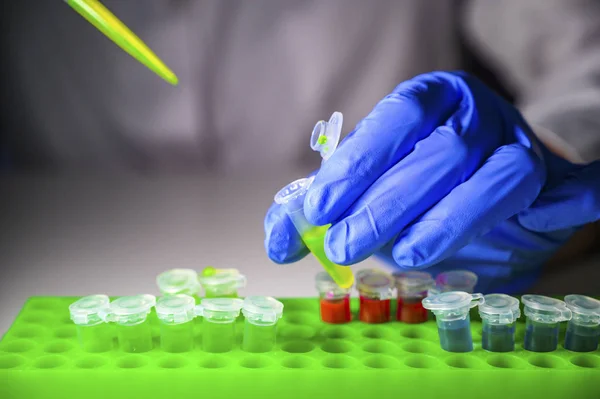 Scientist taking out green chemical solution from eppendorf tube