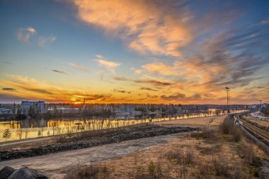 İsveç 'in kuzeyindeki şehir manzarası macerasıyla akşam günbatımında güneşli bulutların sakin renkli görüntüsü