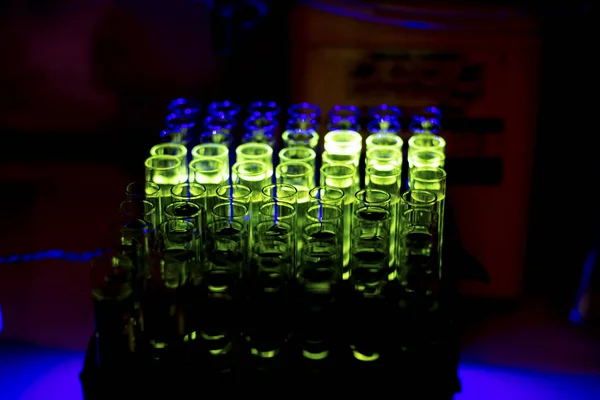 Glowing fluorescent compound collected from column chromatography in a chemistry laboratory for pharmaceutical research