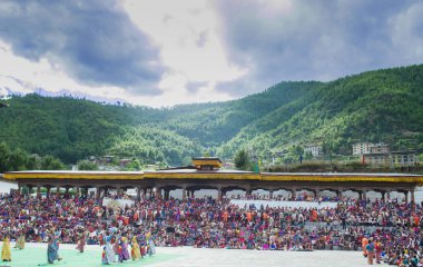 10 Ekim 2019, Thimphu Dzong, Bhutan Bir grup Bhutan dansçısı geleneksel kostümlerini giyip Tsechu festivalini vadi ve tepelerin nefes kesici doğal güzellikleriyle kutluyorlar..
