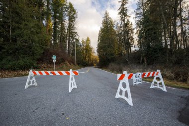 Road closed by barriers blocking access 
