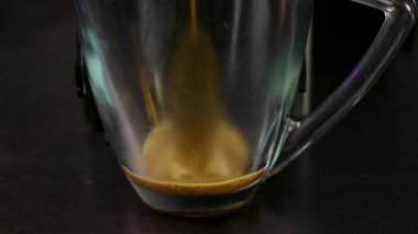Espresso bardağına dökülen kahvenin yakın çekimi.