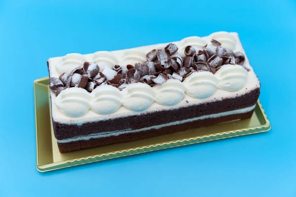 Heerlijke Rechthoekige Chocoladetaart Met Glazuur Geraspte Chocolade Geïsoleerd Blauwe Achtergrond — Stockfoto