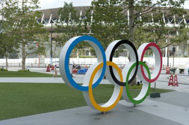 SHINJUKU CITY, TOKYO, JAPAN - SEPTEMBER 30, 2019: Perspective view of Olympic Rings. Background with New National Stadium (Tokyo). clipart