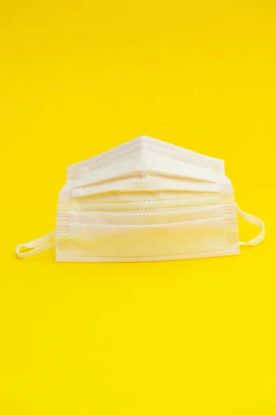 ウイルス インフルエンザや他の病気から保護するためのピンクの外科用マスク 黄色の背景に隔離された スペースのコピー — ストック写真