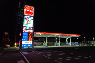 Fuji Şehri, Shizuoka Bölgesi, Japonya - 25 Nisan 2020: Geceleri self-servis ENEOS benzin istasyonu. Yatay çekim.