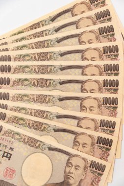 10,000 yenlik banknotlar halinde 100.000 yenlik yakın çekim. Beyaz arka planda izole edilmiş. Dikey çekim.