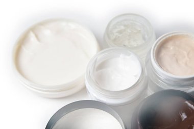 Yüz, eller ve vücut için bakım ürünleri. Beyaz arka planda kavanozlarda krema