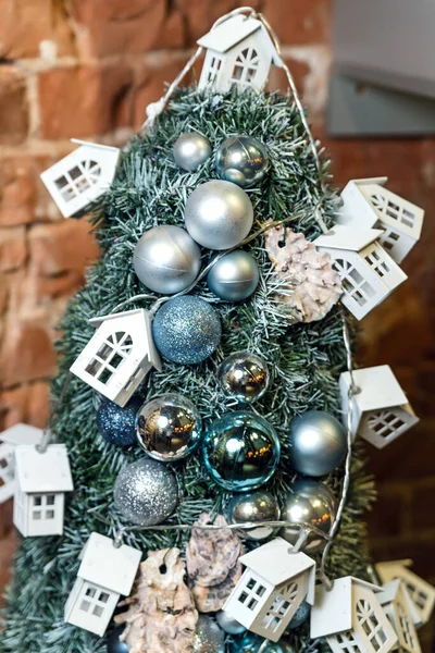 Kerstboom Close Versierd Met Kerstballen Speelgoed Huizen Baksteen Muur Achtergrond — Stockfoto