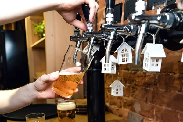 Mans mano versando pinta di birra dietro il bar dal rubinetto . — Foto Stock