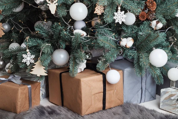 Geschenkdozen Verpakt in kraftpapier liggen onder de kerstboom. — Stockfoto