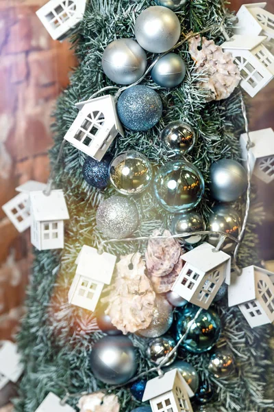 Kerstboom close-up versierd met kerstballen en speelgoed huizen — Stockfoto