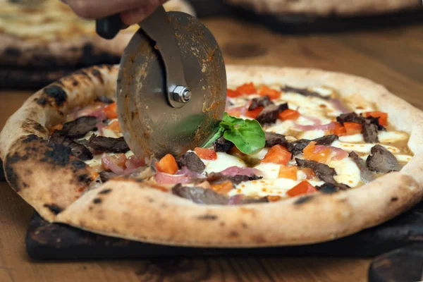 Cocinar pizza cortada con un cuchillo redondo — Foto de Stock
