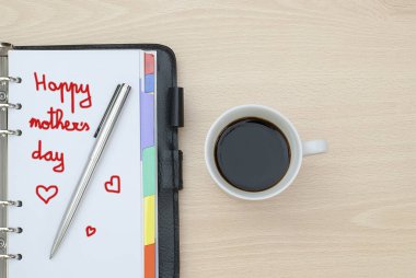 Bir fincan kahve ve not defterine yakın çekim. Anneler Günün kutlu olsun.