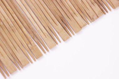 Yemek çubuğu hasırı. Çubuklar ahşap arka plan, köşegen. Beyaz arkaplan üzerindeki metin için kopyalama alanı olan üst görünüm.