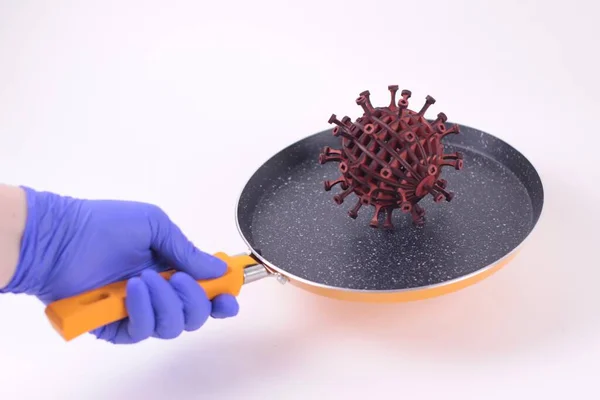 Salgın, covid19 ve yüksek ısı kavramı. Mavi tıbbi eldivende odaklanmamış bir el Coronavirus 'un 3D modelli tavasını tutuyor. Beyaz arka plan..