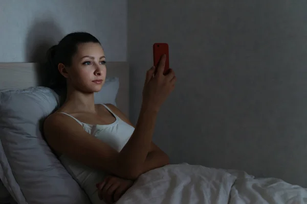 Jong vrouwtje verslaafd staren naar haar smartphone laat op de avond — Stockfoto