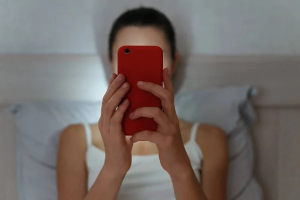 Jonge vrouw browsen met smartphone laat op de avond. Gericht op: — Stockfoto